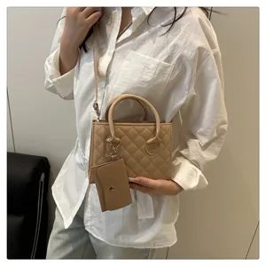 Chic quilted crossbody bag with top handle and coin purse charm for everyday fashion style.