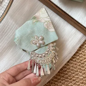 Pinza para el pelo de tela verde estilo chino con flor de perla y flecos plateados.