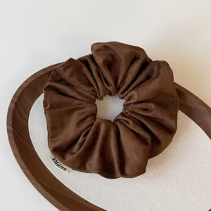 Braunes Wildleder Haarscrunchie Detailansicht, weicher Samt Haargummi für elegante Damen.