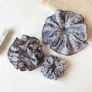 Vue détaillée de chouchous léopard bleus, tissu doux, volants et étiquette artisanale.