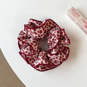Chouchou double couche en tissu imprimé léopard rouge, accessoire de coiffure stylé.