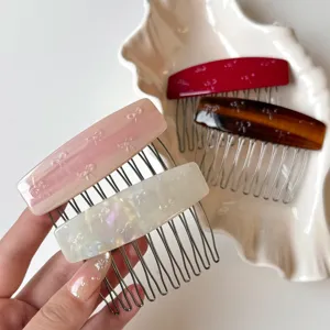 Dettagli delicati del pettine per capelli in acetato con graziosi fiocchi, elegante.