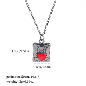 Macro detail view of gothic teddy bear necklace with a red heart gemstone and size info