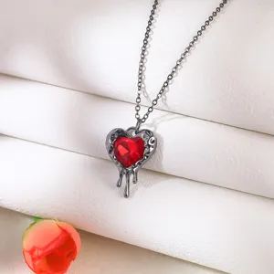Close-up detail of a Gothic style red melting heart pendant necklace with a dark metal chain