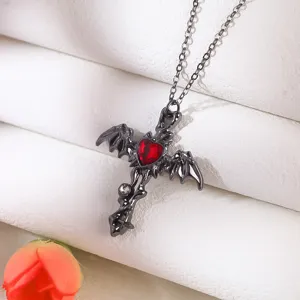 Close-up detail of a gothic black cross necklace featuring a red heart gemstone and bat wings