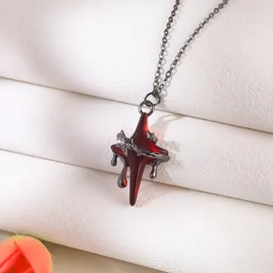 Detailed macro view of a gothic red star pendant necklace featuring metallic drip design and butterfly