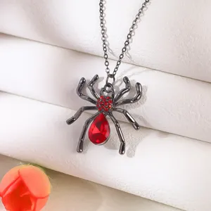 Close-up detail of gothic spider necklace pendant with vibrant red gemstones.