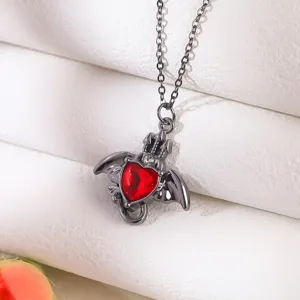 Macro detail of Gothic necklace featuring a red heart gem with black bat wings