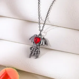 Detailed shot of gothic necklace featuring a red heart and bat wings pendant
