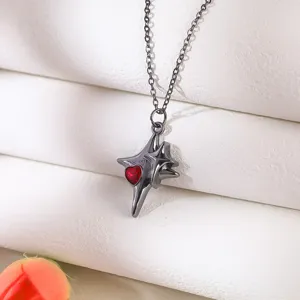 Close-up of a gothic black cross necklace featuring a central red heart gemstone