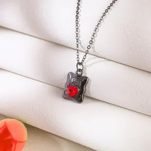 Macro view of a Gothic black bear pendant necklace with a vibrant red heart gem