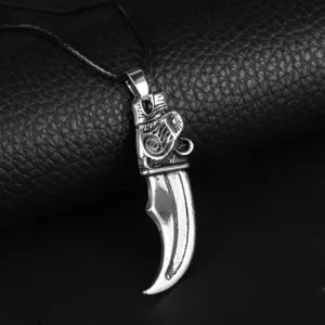 Vintage Viking wolf tooth pendant for men with intricate engravings on black leather background