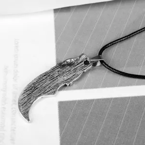 Close-up of textured Viking wolf tooth pendant with rustic silver finish