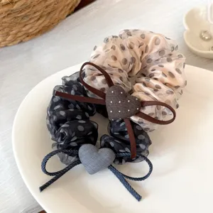 Vue détaillée de chouchou à pois en organza doux avec joli cœur, élastique pratique.