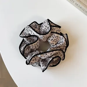 Coletero de pelo elegante con estampado de leopardo blanco y negro y borde enrollado.