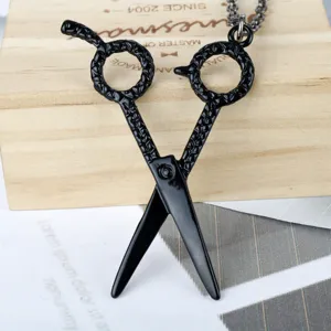 Detail shot of a creative black hairstylist scissor pendant necklace with textured handles