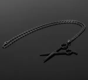 Detail view of a creative black scissor pendant necklace for hairstylists