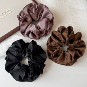 Close-up details of four-layer pleated satin hair scrunchies showcasing fine texture.