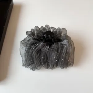 Detail of sparkly organza hair claw clip with rhinestones for elegant styling and hair volume.