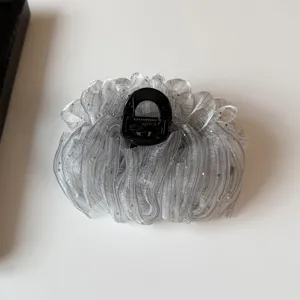 Detailed close-up view of the sparkling silver organza hair claw clip, highlighting texture.