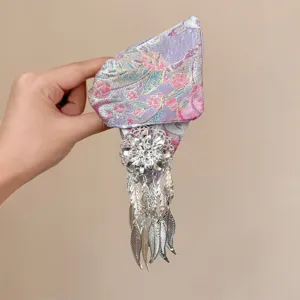 Chinese style hair claw clip metallic leaf tassel brocade detail close up elegant accessory