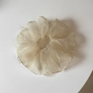Vista detallada de un coletero beige transparente y esponjoso para peinados diarios.