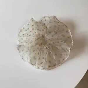 Primer plano de un coletero transparente de lunares con delicados bordes con volantes.