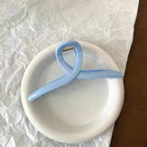 Dettaglio molletta per capelli in acrilico azzurro, elegante accessorio geometrico per capelli folti.