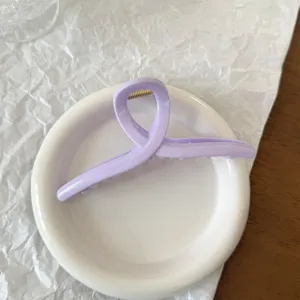 Primo piano dettagliato di un elegante fermaglio per capelli in acrilico viola chiaro