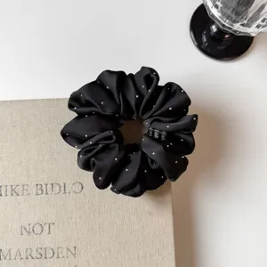 Close-up of black satin hair scrunchie with rhinestones, elegant Korean style hair tie.