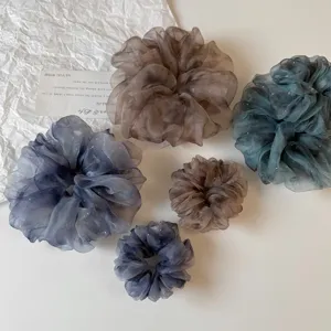 Gros plan sur des chouchous en organza dégradé transparents avec de subtils reflets brillants.