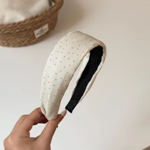 Detailed view of the chic cream wide polka dot fabric headband, elegant Korean hair accessory.