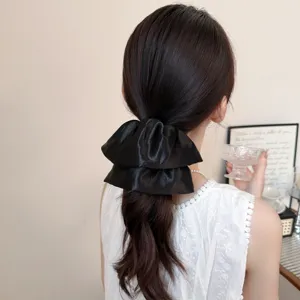 Elegante zwarte satijnen haarelastiek, glanzende gelaagde haardas voor stijlvolle vrouwen.