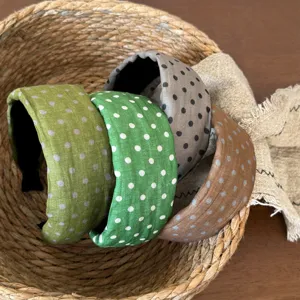Detail shot of stylish polka dot wide headbands in various colors arranged inside a woven basket.