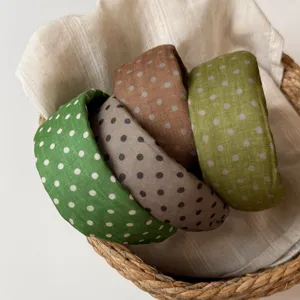 Detailed view of fashionable polka dot wide padded headbands in a woven basket, chic Korean style.