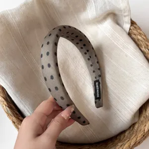 Detailed view of a stylish polka dot wide headband, Korean fashion hair accessory for women.