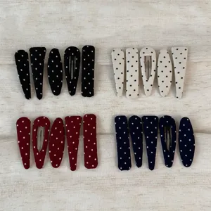 Close-up detail of cute polka dot hair clips set, fabric-wrapped snap hair clips for women.