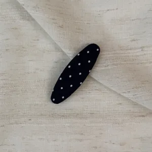 Detail shot of black polka dot hair clip for women side fringe and bangs styling accessory