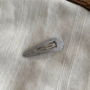Detalle de horquilla de pelo de tela plisada plateada con lunares, bonito pasador.