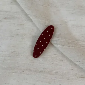 Close-up detail shot of a cute polka dot fabric hair clip, featuring a stylish daily design.