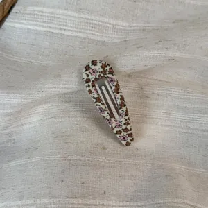 Close-up detail of a cute Korean pastoral floral fabric oval BB hair clip with nice texture.