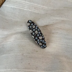 Close-up detail of a Korean pastoral floral fabric oval snap hair clip with blue flowers.
