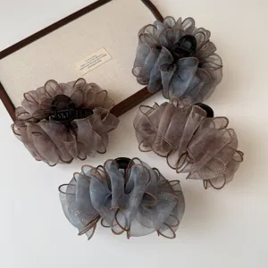 Vista detallada de pinzas para el cabello de organza esponjosa con diseño de malla transparente elegante.