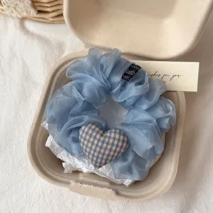 Μπλε scrunchie μαλλιών από οργάντζα με καρό καρδιά λεπτομερής όψη σε χάρτινη συσκευασία.