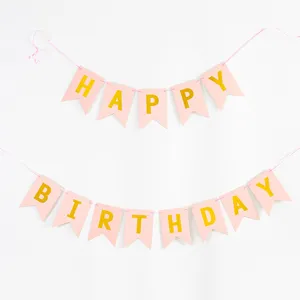 Close-up of pink Happy Birthday banner with elegant gold foil letters for party decor.