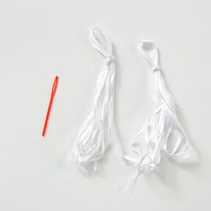 Two bundles of white ribbon and one red plastic threading needle for DIY banner assembly