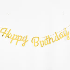 Macro view of the shiny golden Happy Birthday script banner for party decoration