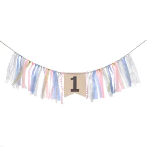 Close-up of baby girl 1st birthday high chair banner with pink and blue ribbons