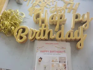 Detailed view of shiny gold Happy Birthday cardstock bunting letters and gold strings