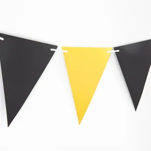 Vista detallada de la guirnalda de banderines de papel negro y amarillo para fiestas.